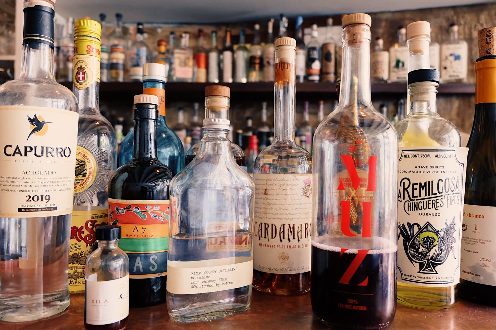 Bottles on the bar back for cocktail hour at a Comparti wedding